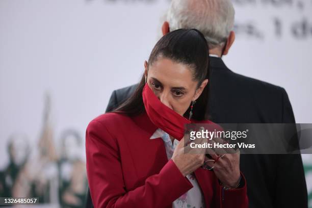 Head of Government of Mexico City Claudia Sheinbaum takes off her face mask during the ceremony to commemorate the third year of Lopez Obrador's...