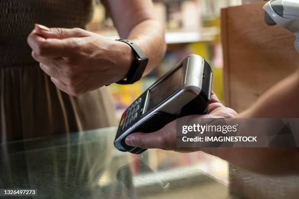 contactless payment with smart watch in-store - computer indossabile foto e immagini stock