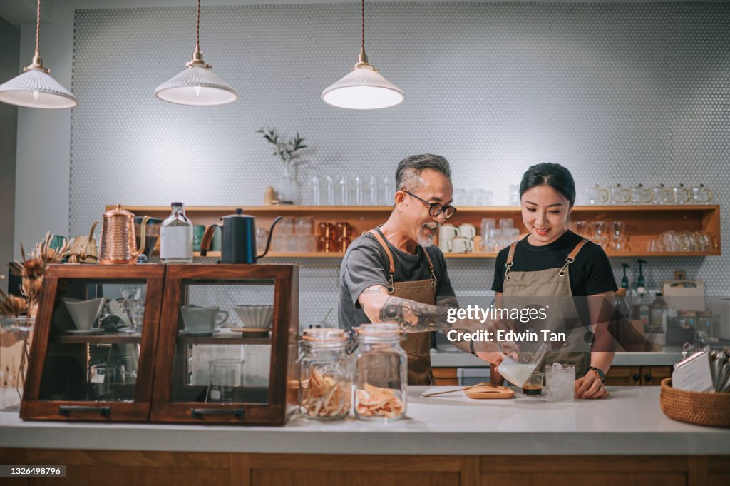 Asiatische chinesische Senior männlichen Barista lehrt seine Tochter Kaffee in Café-Bar-Theke