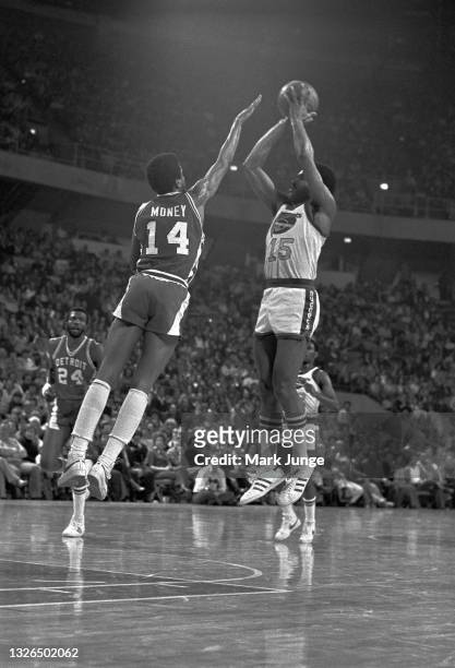 Denver Nuggets guard Jim Price shoots a jumper over the outstretched arms of Detroit Pistons guard Eric Money during an NBA basketball game at...