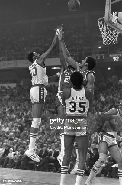 Denver Nuggets center Marvin Webster shoots over Detroit Pistons centers Roger Brown and Leon Douglas during an NBA basketball game against the...