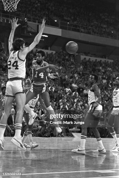 Detroit Pistons guard Eric Money passes the ball while driving to the hoop against Denver Nuggets forward Bobby Jones during an NBA basketball game...