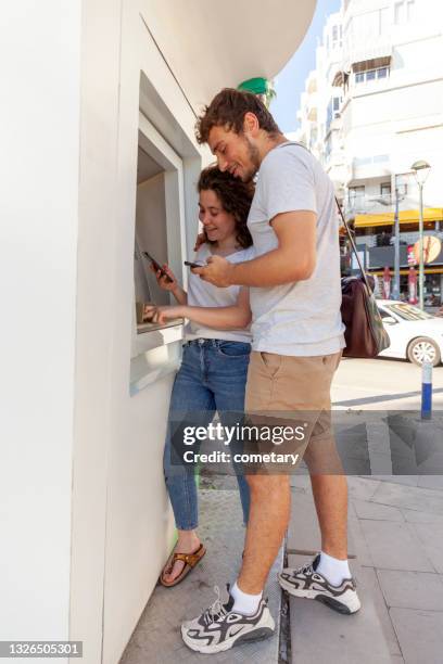 friendship who entered the code on the phone and tried to withdraw money at the atm - man atm smile stock pictures, royalty-free photos & images