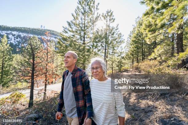 aktives rentnerpaar beim wandern im wald - mature couple outdoors stock-fotos und bilder