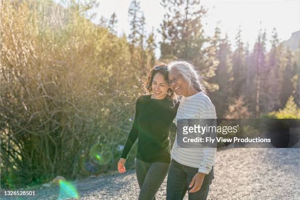 portrait of beautiful mixed race senior woman spending time with her adult daughter outdoors - friendship stock pictures, royalty-free photos & images