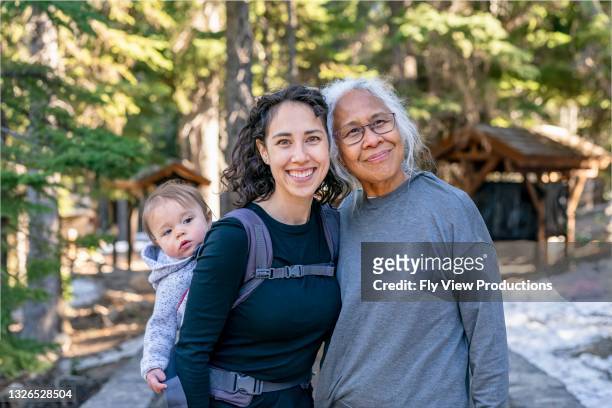 glückliche mehrgenerationenfamilie genießt naturwanderung - asian mother daughter stock-fotos und bilder