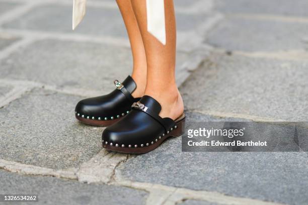 Xenia Adonts wears black leather Hermes studded clogs / shoes, during the Twilly By Hermes : Launch Party In Paris, on July 01, 2021 in Paris, France.