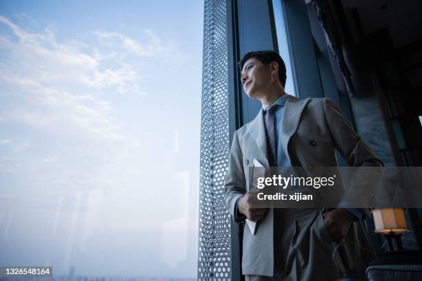 geschäftsmann schaut durch fenster - asia business man stock-fotos und bilder