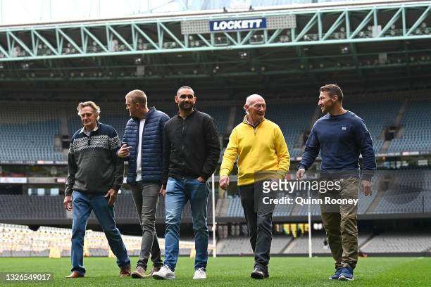 Michael Tuck, Dustin Fletcher, Shaun Burgoyne, Kevin Bartlett and Brent Harvey walk together across Marvel Stadium during a media opportunity at...