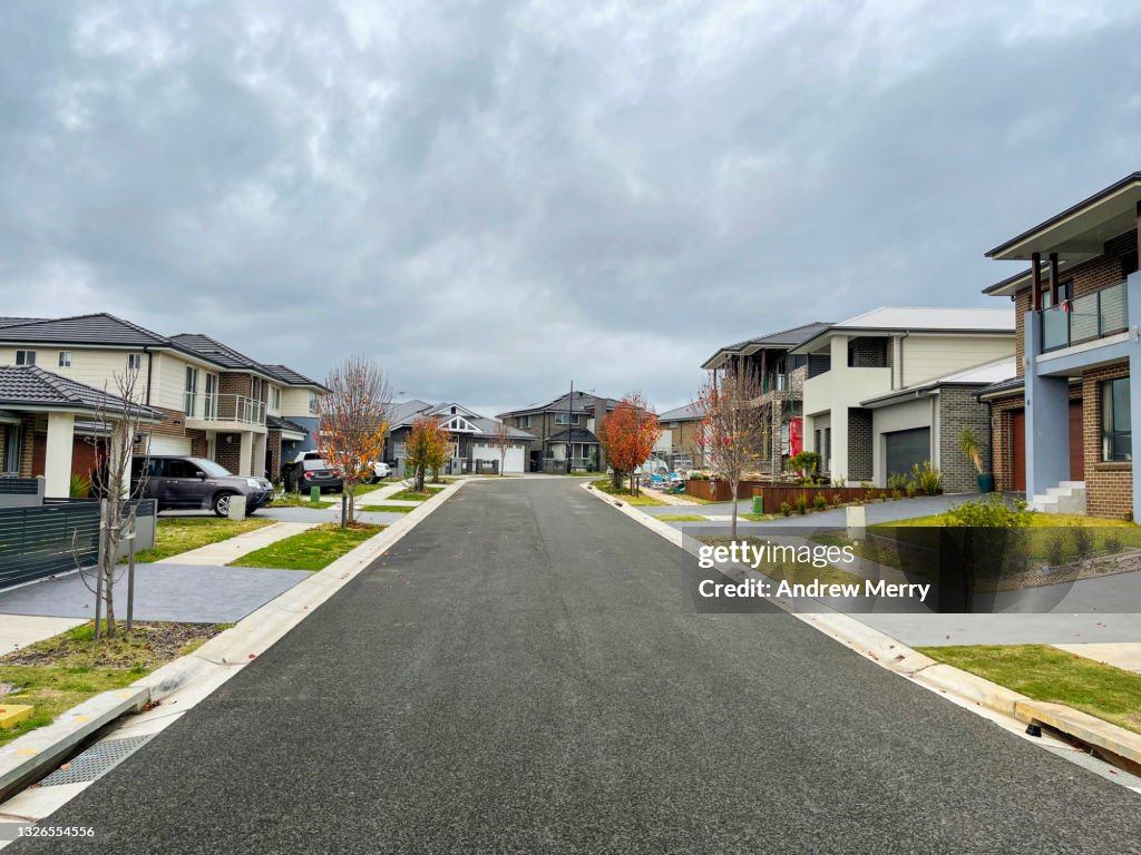 Houses along suburban street and overcast sky