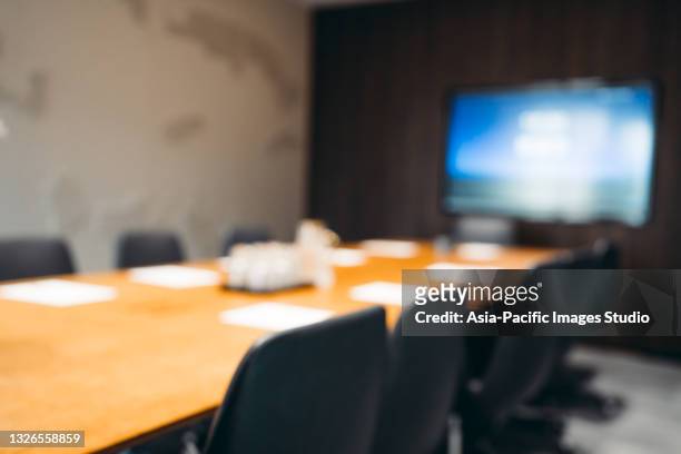 defocused blurred modern empty meeting room with big conference table. - board room stock pictures, royalty-free photos & images