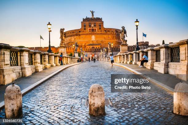 a suggestive and pictorial twilight scene of ponte sant'angelo in the historical and baroque heart of rome - ballustrade stockfoto's en -beelden