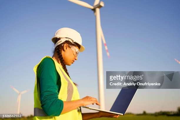 female engineer setting up wind turbine. - sustainable investment stock pictures, royalty-free photos & images