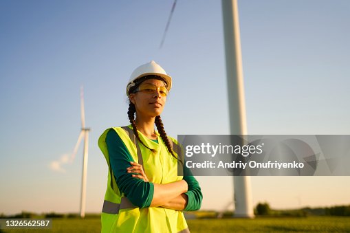 Female engineer setting up wind turbine. Female engineer setting up wind turbine.