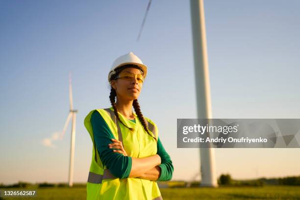 female engineer setting up wind turbine. - african american female foto e immagini stock