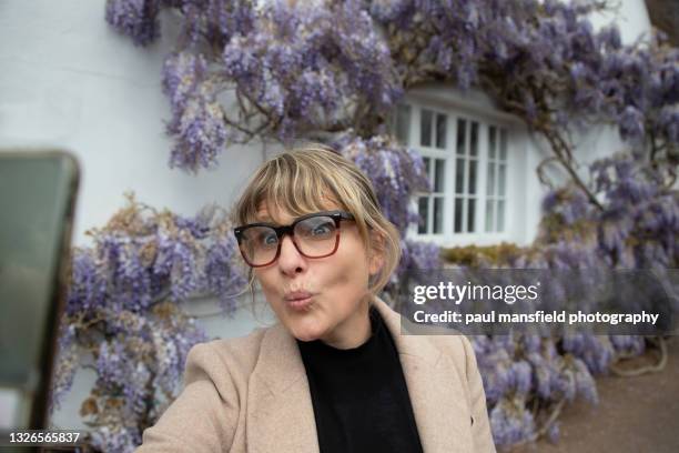 smartly dressed lady taking selfie - blonde woman selfie stockfoto's en -beelden