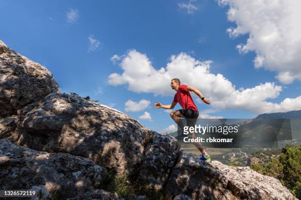 young man running on mountain - forward athlete stockfoto's en -beelden