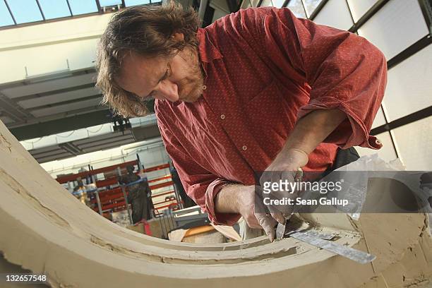 Sculptor Jens Cacha creates a corbel from clay at the Schlossbauhuette studio where a team of sculptors is creating decorative elements for the...