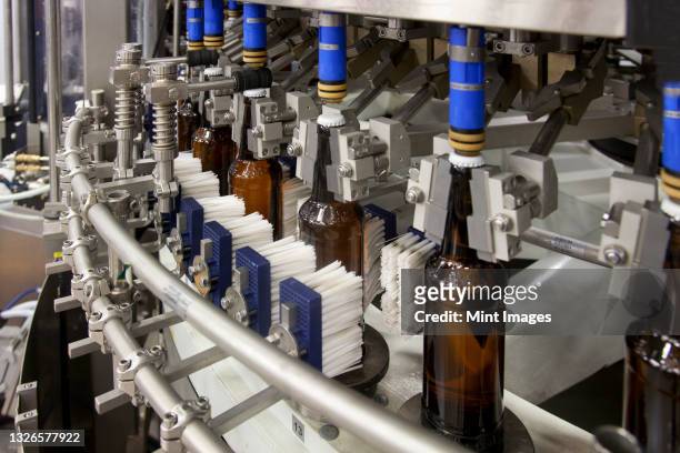 automated and mechanised beer bottling plant - tappo birra foto e immagini stock
