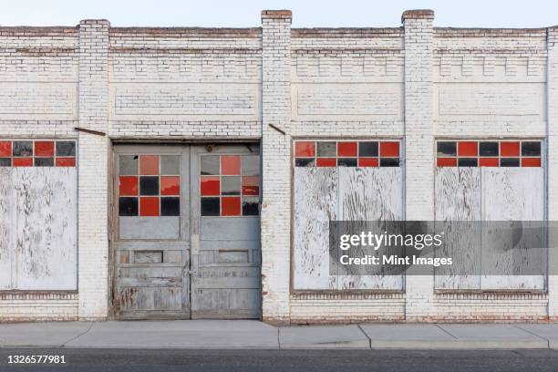 a boarded up building, a closed business on main street. - ricoperto di assi foto e immagini stock