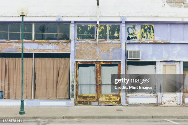 main street with boarded up windows, closed business - dichtgetimmerd stockfoto's en -beelden