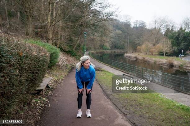 endurance is key - hand op knie stockfoto's en -beelden