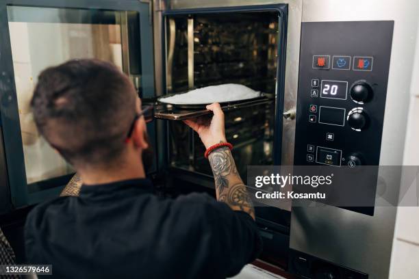 chef profesional, poniendo la lubina cubierta de sal en el horno para hornear - sales occupation fotografías e imágenes de stock