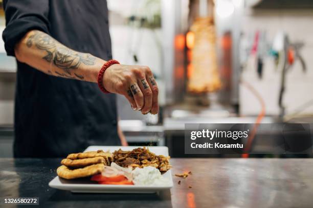 chef assaisonne l’assiette avec des gyros au sel, prêt à être servi - tzatziki photos et images de collection