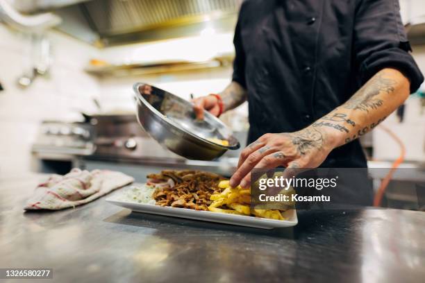 um ein paar pommes frites hinzuzufügen, und dieser teller kann unseren kunden serviert werden - shawarma stock-fotos und bilder