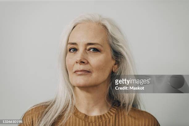 portrait of mature woman against white background - white hair stock-fotos und bilder