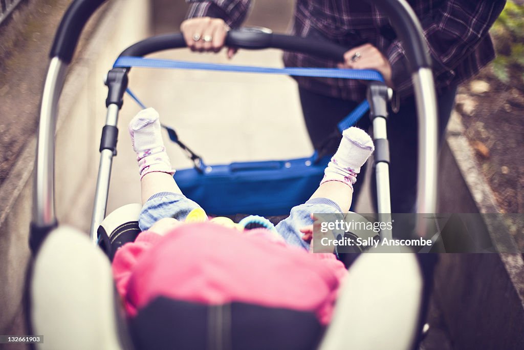 Mother pushing baby in pram