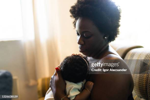 madre cuidando al bebé - black mother holding newborn fotografías e imágenes de stock