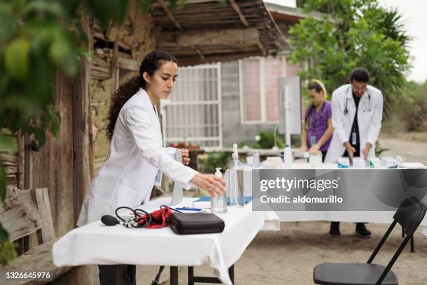 des professionnels de la santé installent une table dans les zones rurales - brigade photos et images de collection