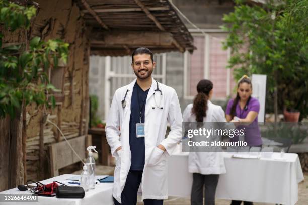 un médecin en milieu rural souriant à la caméra - brigade photos et images de collection