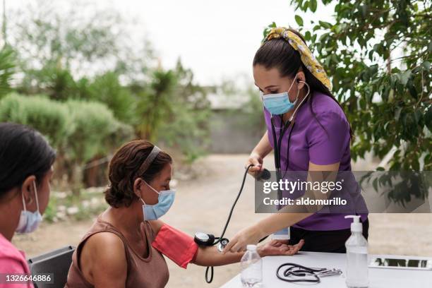 nurse on brigade checking senior patient outside - brigade stock pictures, royalty-free photos & images