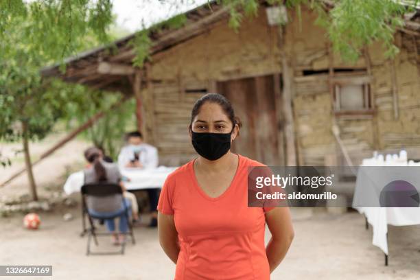 patiente latino portant un masque dans une zone rurale - brigade photos et images de collection
