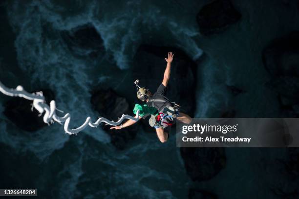 a man bungee jumps from a bridge spanning a gorge in nepal - leap of faith activity stock pictures, royalty-free photos & images