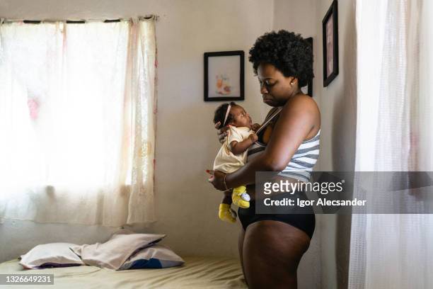mother in panties holding baby - new mother stock pictures, royalty-free photos & images
