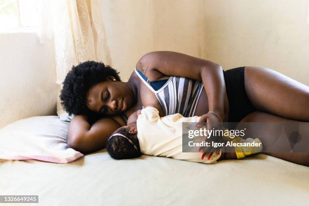 madre amamantando en la cama - black slip fotografías e imágenes de stock