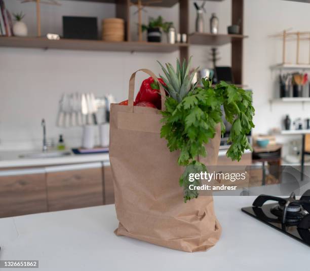 bag of fresh groceries on top of the  kitchen counter - kitchen bench top stockfoto's en -beelden