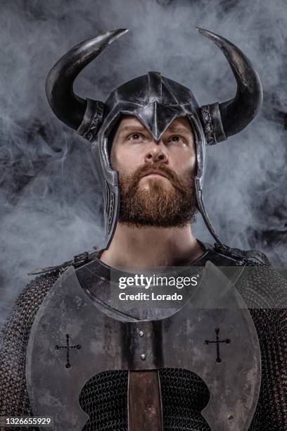 viking wearing horned helmet on a black background - ancient vikings stockfoto's en -beelden