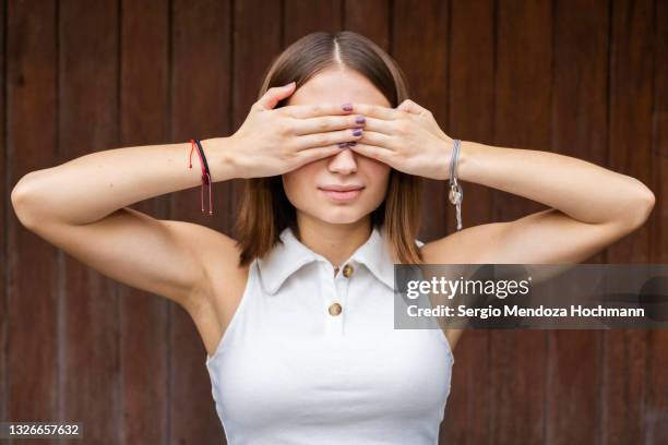 young mexican woman covering her eyes, see no evil - 目隠し ストックフォトと画像