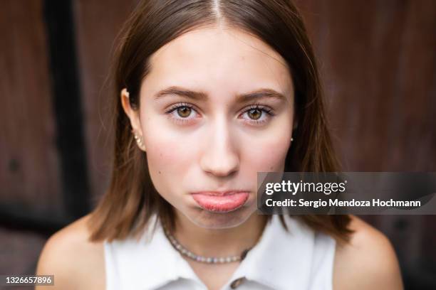 young latino woman looking up at the camera with disappointment, sulking with her lower lip out, about to start crying like a child - pleading stock pictures, royalty-free photos & images