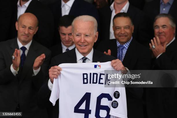 President Joe Biden holds the jersey given to him by the Los Angeles Dodgers during an event with the 2020 World Series champions in the East Room of...