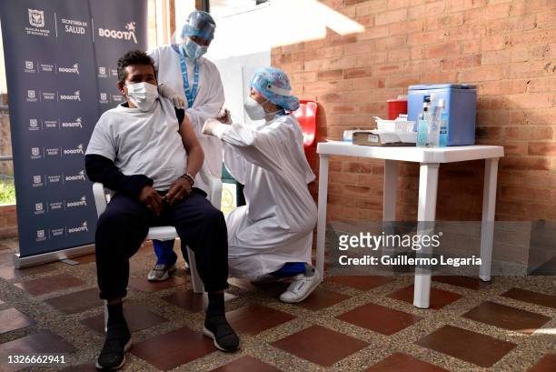 Health worker gives a homeless man a shot of the Jenssen COVID-19 vaccine from the Johnson & Johnson laboratory at Centro Crecer Balcanes municipal...