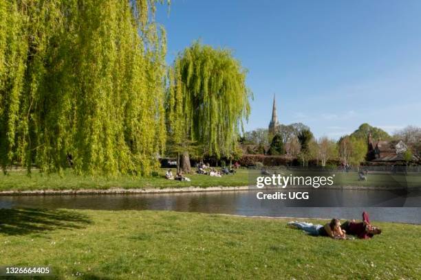 Salisbury, Wiltshire, England, UK, People enjoying the Queen Elisabeth Gardens overlooking the River Avon close to the city center.