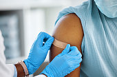 Shot of a doctor applying a plaster to her patients arm
