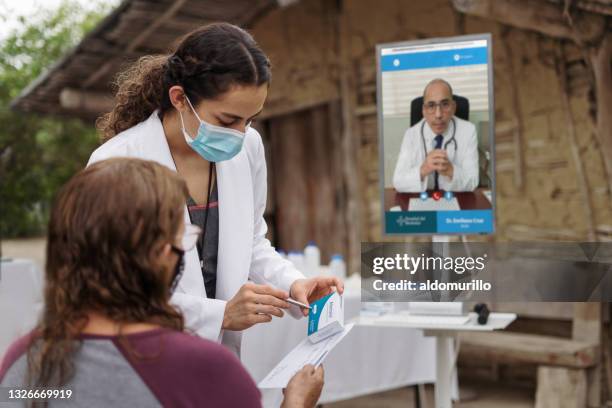 doctora que da medicina al paciente en la zona rural - flu mask in mexico fotografías e imágenes de stock