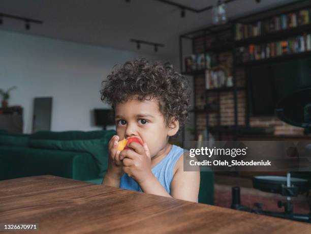portrait of black boy 3 years old eating peach - 2 3 years stock pictures, royalty-free photos & images