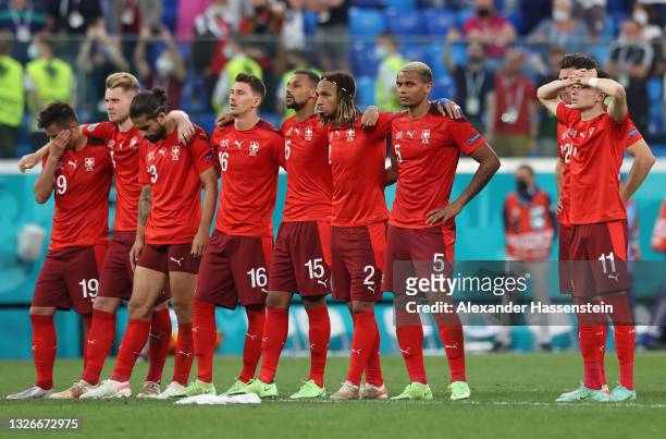 Switzerland players look on from the half way line during the penalty shoot out the UEFA Euro 2020 Championship Quarter-final match between...